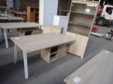 several desks and cabinets in a warehouse with a truck in the background