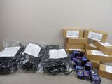 Plusieurs cartons et colis contenant du matériel électronique sont posés par terre.