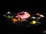 un gros plan sur un ensemble de pierres précieuses de différentes couleurs posées sur une surface noire