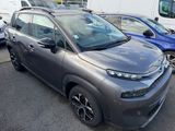 a grey citrole parked in a parking lot next to other cars
