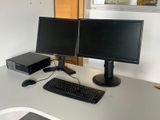 deux écrans d'ordinateur et un clavier sur un bureau