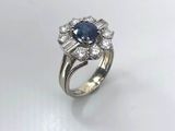 a close up of a diamond and sapphire ring on a white surface