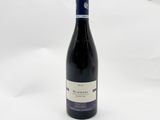 une bouteille de vin rouge posée sur une table blanche