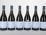 six bouteilles de vin sont alignées sur une table