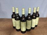 six bottles of wine sitting on top of a wooden table