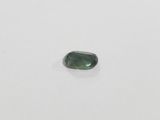 a green tourmaline stone on a white surface