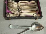 a box of silver spoons and spoons sitting on a table
