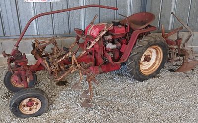 un tracteur rouge garé devant un bâtiment