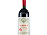 une bouteille de vin rouge posée sur une table blanche