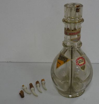 une bouteille en verre contenant des brosses à dents et du dentifrice