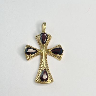 une image représentant une croix en or ornée de grenats
