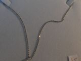 silver necklace with a lock and chain attached to it on a white surface