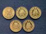 four gold coins with a coat of arms on them on a blue cloth