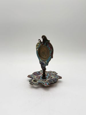 an image of a small metal object sitting on top of a white surface
