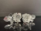 trois roses en cristal posées sur une surface noire