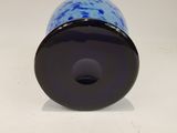 a close up of a blue vase on a white surface