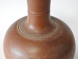 a brown vase that is sitting on a table