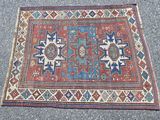 un vieux tapis posé à même le sol, orné d'un motif bleu et rouge