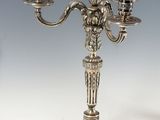 a silver candelab with three candles on top of it