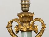 a gold and green vase on a white table