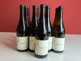 six bouteilles de vin sont alignées sur une table