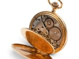 a gold pocket watch sitting open on a white surface