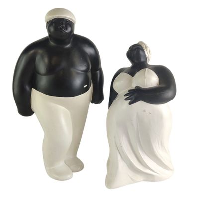 two figurines of a man and a woman standing next to each other