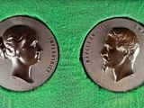 deux médailles commémoratives représentant la reine et le prince d'Angleterre, posées sur un tissu vert