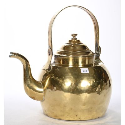 an antique brass teapot with a handle on a white background