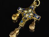 a gold cross with blue and white flowers and bells