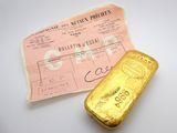 un lingot d'or posé à côté d'un ticket de caisse sur une table