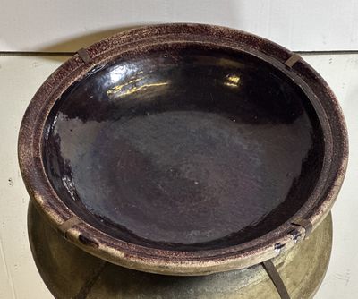 a brown bowl sitting on top of a metal pot