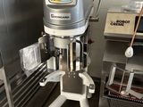 a machine that is sitting in a kitchen next to a shelf