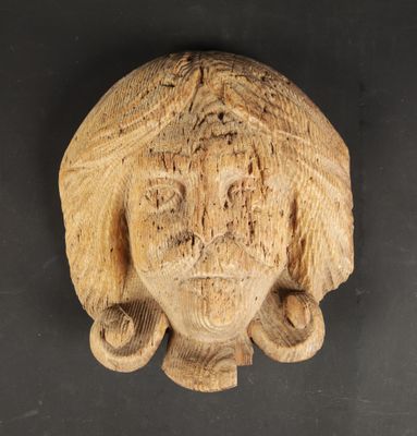 un gros plan sur une sculpture représentant une tête de femme posée sur une surface noire