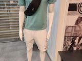 a mannequin dressed in a green shirt and white shorts