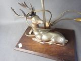 a metal sculpture of a deer with horns on a wooden base