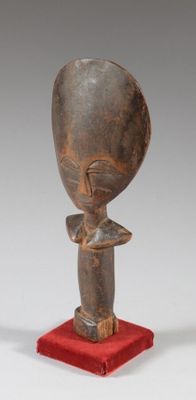 a wooden sculpture of a man with a head on a red stand