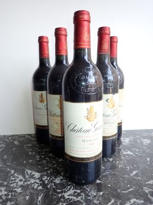 Quatre bouteilles de vin rouge sont alignées sur une table en marbre
