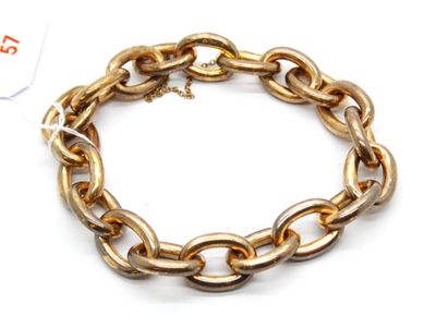 gros plan d'un bracelet en chaîne en or sur fond blanc