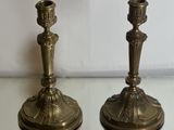 pair of antique brass candlesticks on glass table with white background