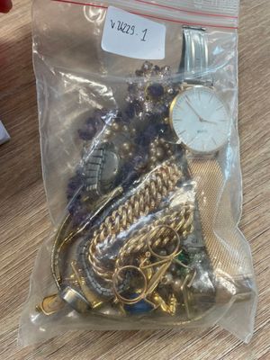 un sac rempli de bijoux en or et en argent posé sur une table