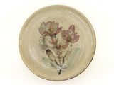a small plate with flowers on it on a white surface
