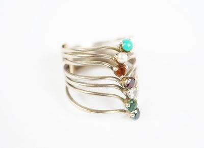 five rings with different colored stones on them on a white surface