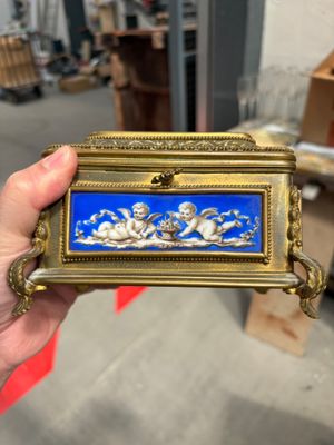 Quelqu'un tient une boîte bleue et dorée décorée d'anges.