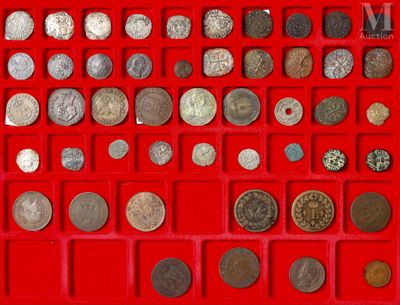an assortment of silver and bronze coins in a red tray