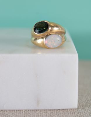 un gros plan d'une bague en or ornée de deux oplites