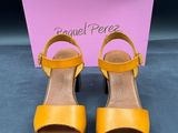 une paire de sandales jaunes avec une boîte sur un fond bleu