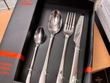 someone is holding a box with a set of silverware in it