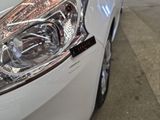 a close up of a headlight on a white car