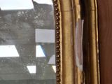a mirror with a gold frame on the wall
